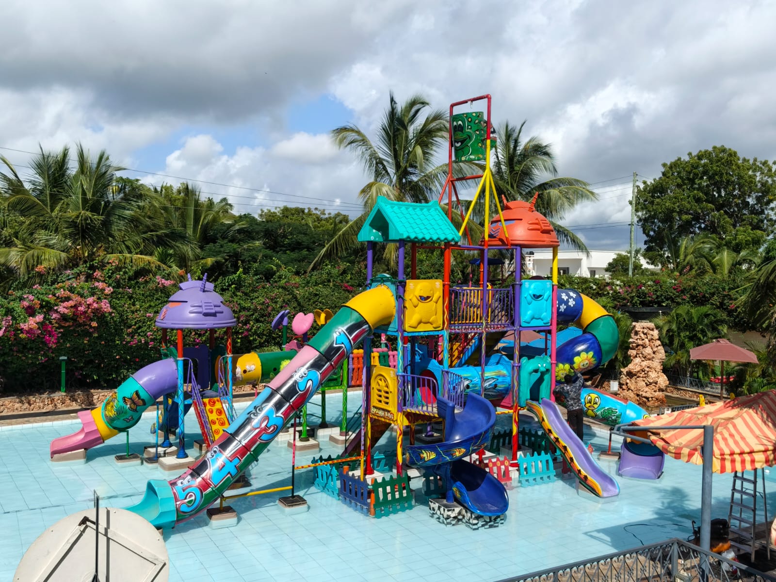 Colorful water slides with children sliding into a pool
